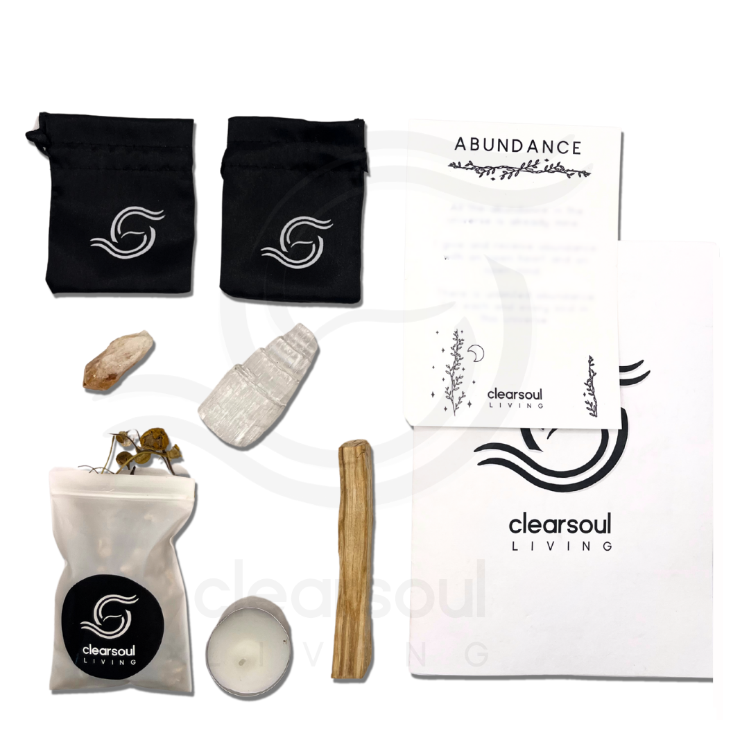 Abundance ritual kit for prosperity featuring Citrine, Selenite Tower, Palo Santo, affirmation card, candle, crystal pouch, and dried chamomile.