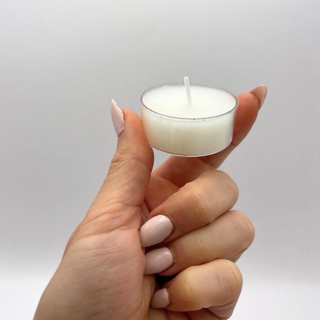 Hand holding an organic soy candle from Clear Soul Living, included in every ritual kit to support intention setting and create a calming atmosphere.