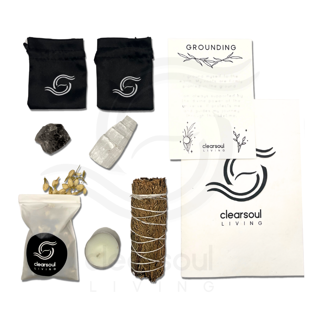 rounding ritual kit featuring Smokey Quartz, Selenite Tower, Cedar smudge stick, affirmation card, soy candle, crystal pouch and dried jasmine flowers.